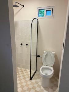 a bathroom with a toilet and a shower at La punta surfhouse 2 in Puerto Escondido