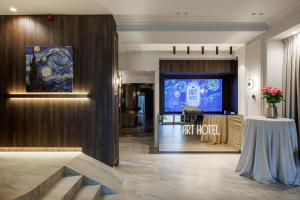 a lobby of a hotel with a tv and a table at Art Hotel in Chişinău