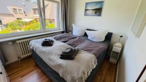 a bedroom with a bed with two towels on it at LUV & LEE Waterkant SPO in Sankt Peter-Ording