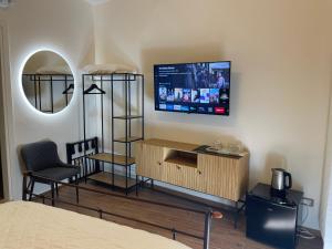a room with a bed and a tv on a wall at Monte Boutique ROOMS in Montepulciano