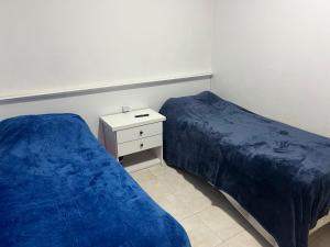 dos camas en una habitación con una mesita de noche y una cama sidx sidx sidx sidx en Alojamiento luxur, en San José