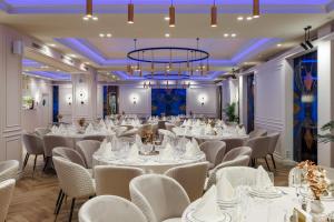 Habitación con mesas, sillas y lámpara de araña. en Art Hotel, en Chişinău