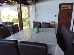 einen Tisch mit einem weißen Tischtuch und eine Vase mit Blumen in der Unterkunft casa Sierras in Sierra de los Padres + 10 Fotos