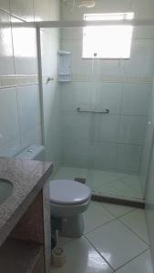 カボ・フリオにあるCasa para temporada em Cabo frioのトイレとガラスのシャワー付きのバスルーム