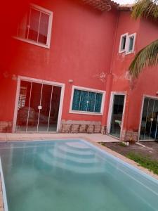 カボ・フリオにあるCasa para temporada em Cabo frioの赤い家の前のスイミングプール