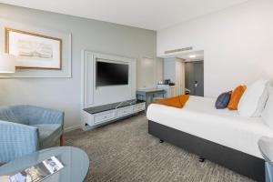 a hotel room with a bed and a television at Millennium Hotel Queenstown in Queenstown