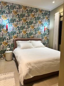a bedroom with a large bed with a floral wallpaper at 603 Apartments in Baddah
