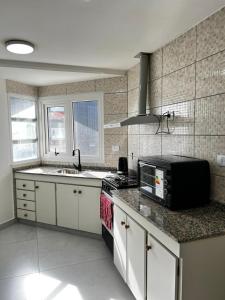 a kitchen with a sink and a microwave on a counter at Downtown rental in Río Grande