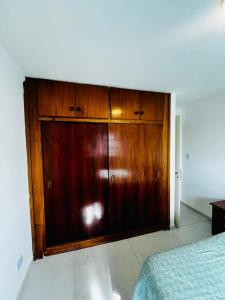 a large wooden cabinet in a bedroom with a bed at Downtown rental in Río Grande