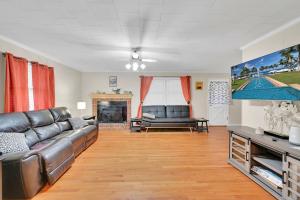 a living room with a couch and a tv at Park your Boat! Mins from the Ocean•Screened Porch in Harkers Island