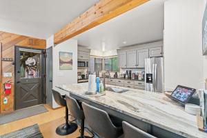 a kitchen with a counter with chairs and a refrigerator at Alpine Cabin in Rhododendron