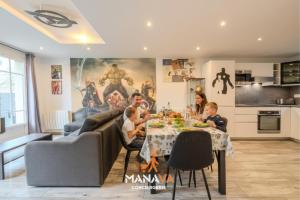 una familia sentada en una mesa en una sala de estar en The Avengers House, en Magny-le-Hongre