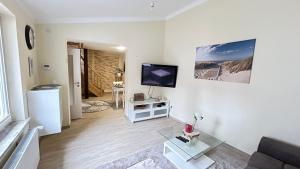 a living room with a couch and a flat screen tv at Ferienhaus Am Trollmönch in Goslar