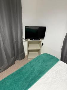 a bedroom with a bed and a desk with a television at Double Cosy bedroom in central Dartford-Close to all amenities in Dartford