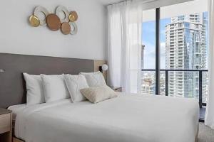 - une chambre blanche avec un grand lit et une grande fenêtre dans l'établissement Stylish High-Rise Corner Unit, à Miami 12 autres photos