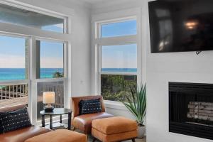 ein Wohnzimmer mit zwei Stühlen und einem Kamin in der Unterkunft Coastal Luxury Condo Steps to the Sand in Seagrove Beach