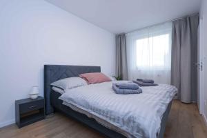 een slaapkamer met een groot bed met kussens erop bij Modern Apartment near Lake & Free parking & Easy City Access in Bratislava