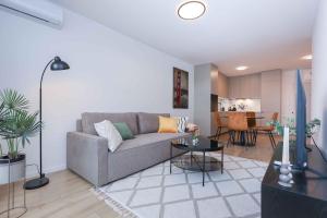 een woonkamer met een bank en een tafel bij Modern Apartment near Lake & Free parking & Easy City Access in Bratislava