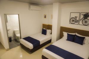 ein Schlafzimmer mit 2 Betten und ein Fahrrad an der Wand in der Unterkunft Hotel Gama Cartagena in Cartagena de Indias + 8 Fotos