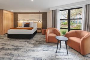a hotel room with a bed and two chairs at Millennium Hotel Queenstown in Queenstown +23 photos