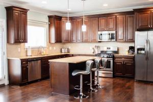 a kitchen with wooden cabinets and stainless steel appliances at Sojourn Beautiful Family Home with Backyard in Ghent in Norfolk
