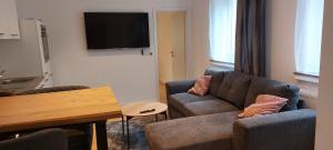 a living room with a couch and a table and a tv at City Appartement in Mönchengladbach
