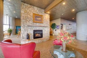 una hall con camino in pietra e sedie rosse di Majestic Mtn Views, Heated Pool! Sugartop Condo a Sugar Mountain