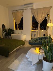a living room with a green couch and a tub at De'Lea Homestay & Hotel in Ho Chi Minh City