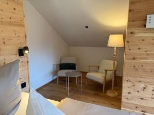 a room with a bed and a table and chairs at DAS BISCHOF - 5 exklusive Ferienwohnungen mit privaten Zirbensaunen - inkl Hindelang PLUS in Bad Hindelang