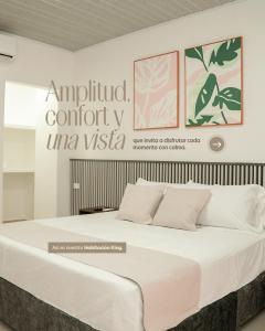 ein großes Bett in einem Zimmer mit Schild in der Unterkunft Hotel Gama Cartagena in Cartagena de Indias