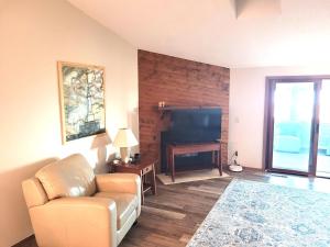 a living room with a couch and a flat screen tv at New! Huron Paradise - Family-friendly Lakefront! in Au Gres