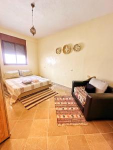 a bedroom with a bed and a couch at Bright Self-Catering 2 bedroom Apartment in Tafraout in Tafraoute
