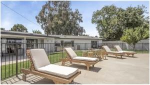 een groep stoelen en een tafel en een hek bij oasis in heart of Clovis in Clovis