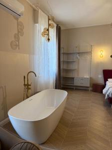 ein Badezimmer mit einer großen weißen Badewanne auf einem Holzboden in der Unterkunft EDA Home in Terni