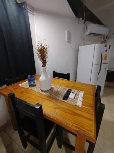 a wooden table with a vase on top of it at Bruna Zona Alta in San Fernando del Valle de Catamarca