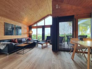 a living room with a couch and a table at Schwarzes Holzferienhaus mit Sauna -- FELDRAIN -- an der Ostsee, Zierow bei Wismar, 4-6 Personen in Zierow