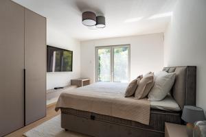 a bedroom with a bed with pillows and a window at Villa Peregrine Plitvice Lakes  +24 photos