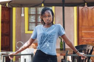 a young woman standing under an umbrella at EKO Holiday Homes, Lake Chala in Chala
