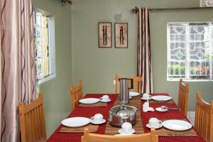 a dining room with a table with a red table cloth at EKO Holiday Homes, Lake Chala in Chala +3 photos