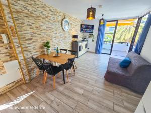 Una sala de estar con una mesa y sillas de madera. en Sunwhere Colon II apartment - Playa De Las Américas, en Arona