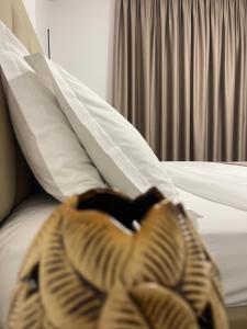 a person laying on top of a bed at Vibe Comfort Tirana in Tirana