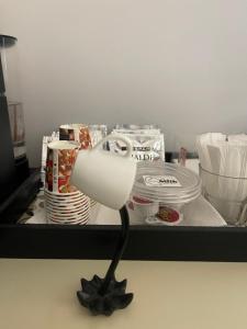 ティラナにあるVibe Comfort Tiranaの皿や食器が入ったトレイの中の白いランプ