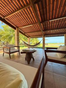 a room with a hammock and a bed and a patio at MHV Milagres - Casa Mar, Refugio a beira mar na Paradisíaca praia da enseada do toque in São Miguel dos Milagres