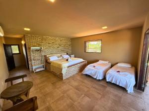 a room with two beds and a brick wall at MHV Milagres - Casa Mar, Refugio a beira mar na Paradisíaca praia da enseada do toque in São Miguel dos Milagres +94 photos