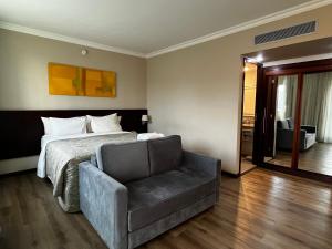 a bedroom with a bed and a chair at Quarto de hotel na Rua Verbo Divino in Sao Paulo