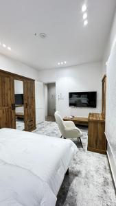 a bedroom with a white bed and a white chair at ملاذ العلا in AlUla