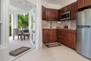 a kitchen with wooden cabinets and a door leading to a patio at Karana Studio 1 - K1 in Long Bay Hills +77 photos