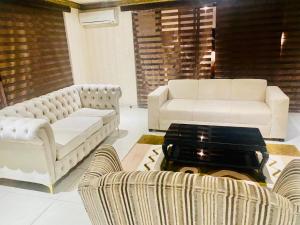 Una sala de estar con dos sofás y una mesa de café. en Grand Tranquil Views, en Lobamba