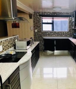 una cocina con encimera y microondas en Grand Tranquil Views, en Lobamba