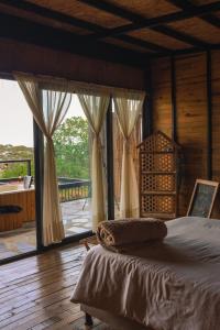 拉维加Finca El Fin del Afán - La Vega的一间卧室，里面有一张床和一扇大窗户。